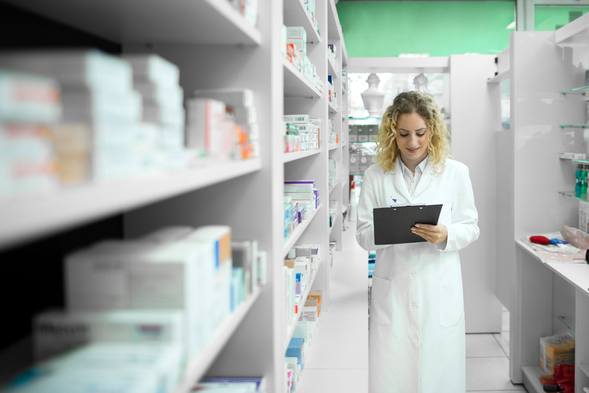 Pharmacist White Uniform Walking By Shelf With Medicines Checking Inventory
