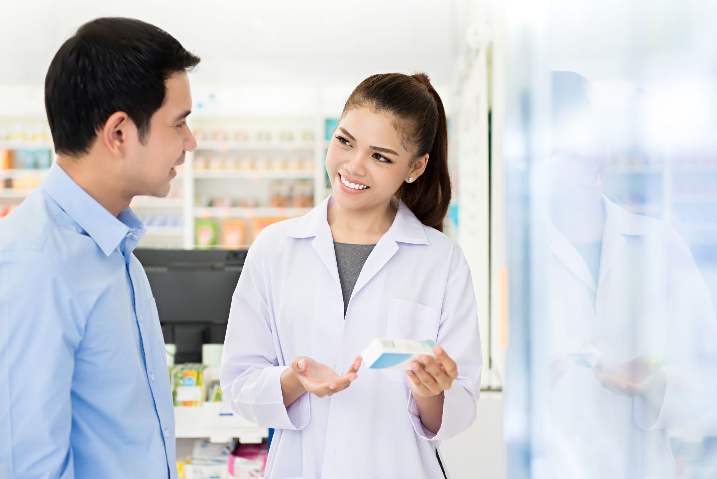 Beautiful Asian Female Pharmacist With Customer Pharmacy